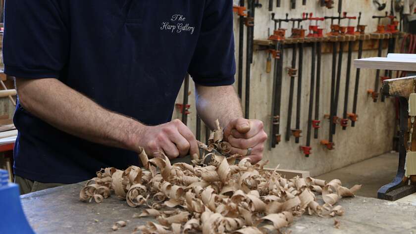 an artisan planing wood