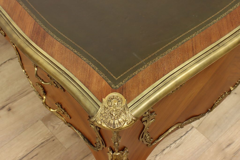 Restored antique desk with leather writing surface and decorative brass hardware
