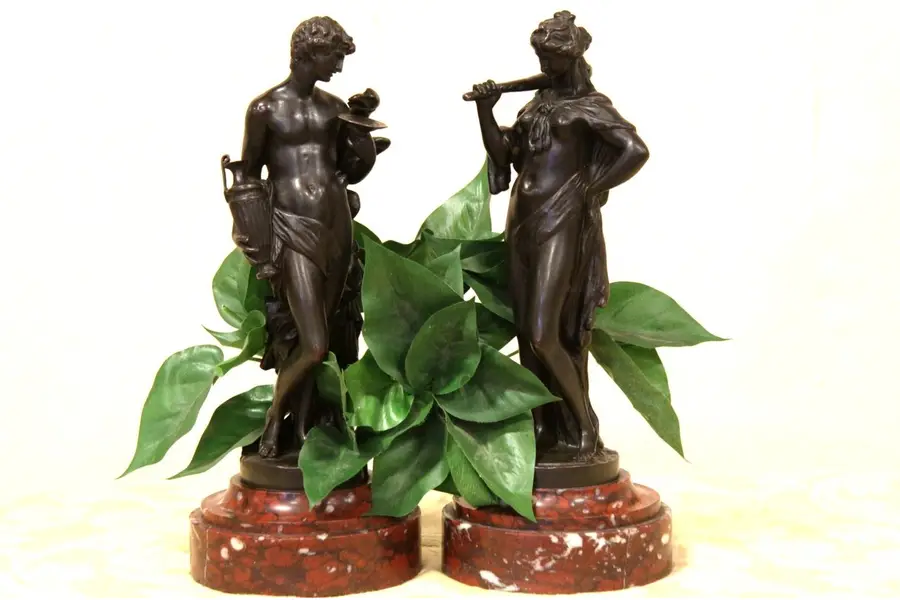 Photo of Two Classical Bronze Sculptures of a Woman and Man